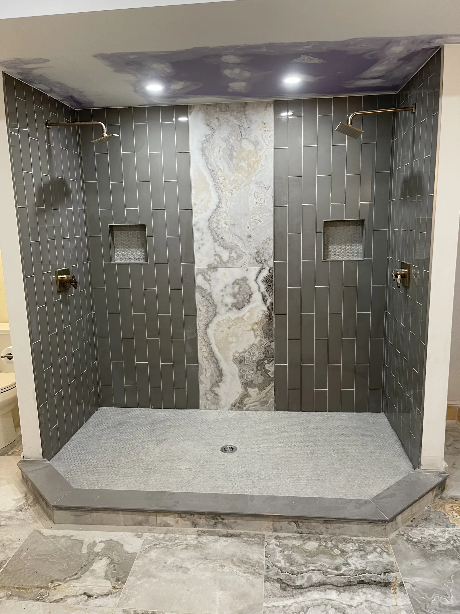 Tiled walk-in shower with contrasting center accent and recessed lights