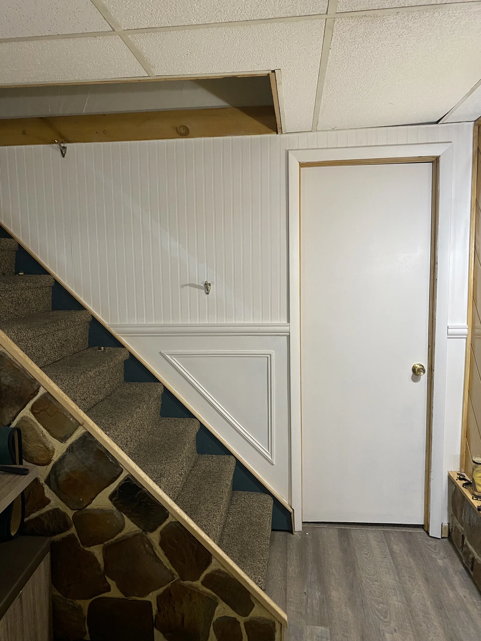 White wall panelling and trim beside a staircase