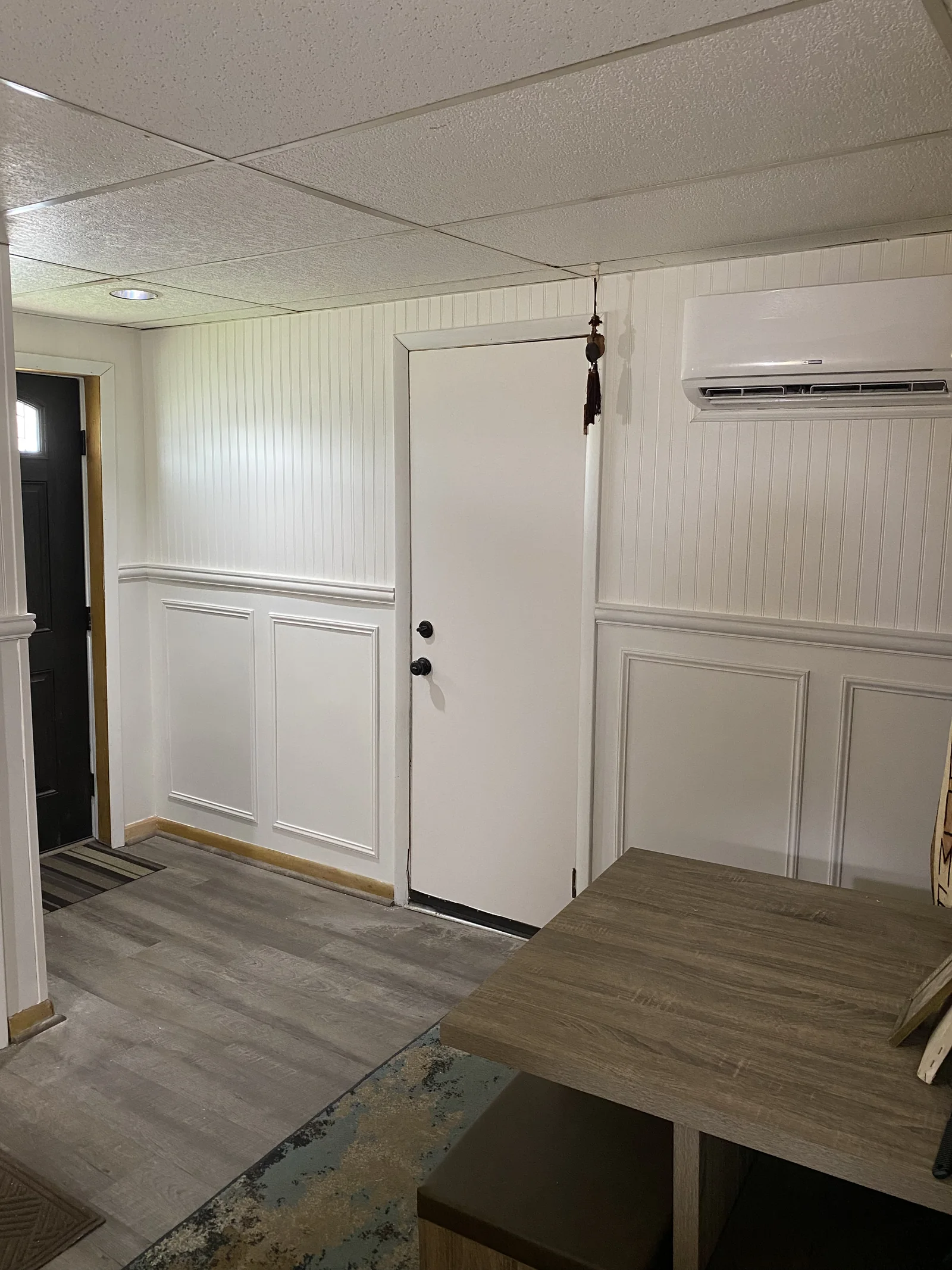 Finished interior with white wall panelling and wood-look flooring