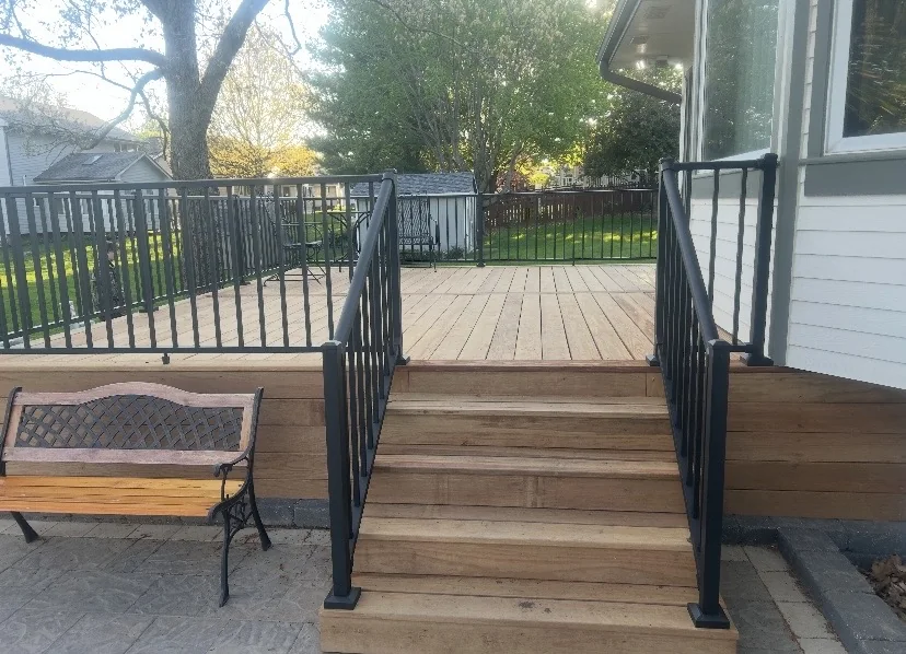 Deck stairs with black handrails and wood treads