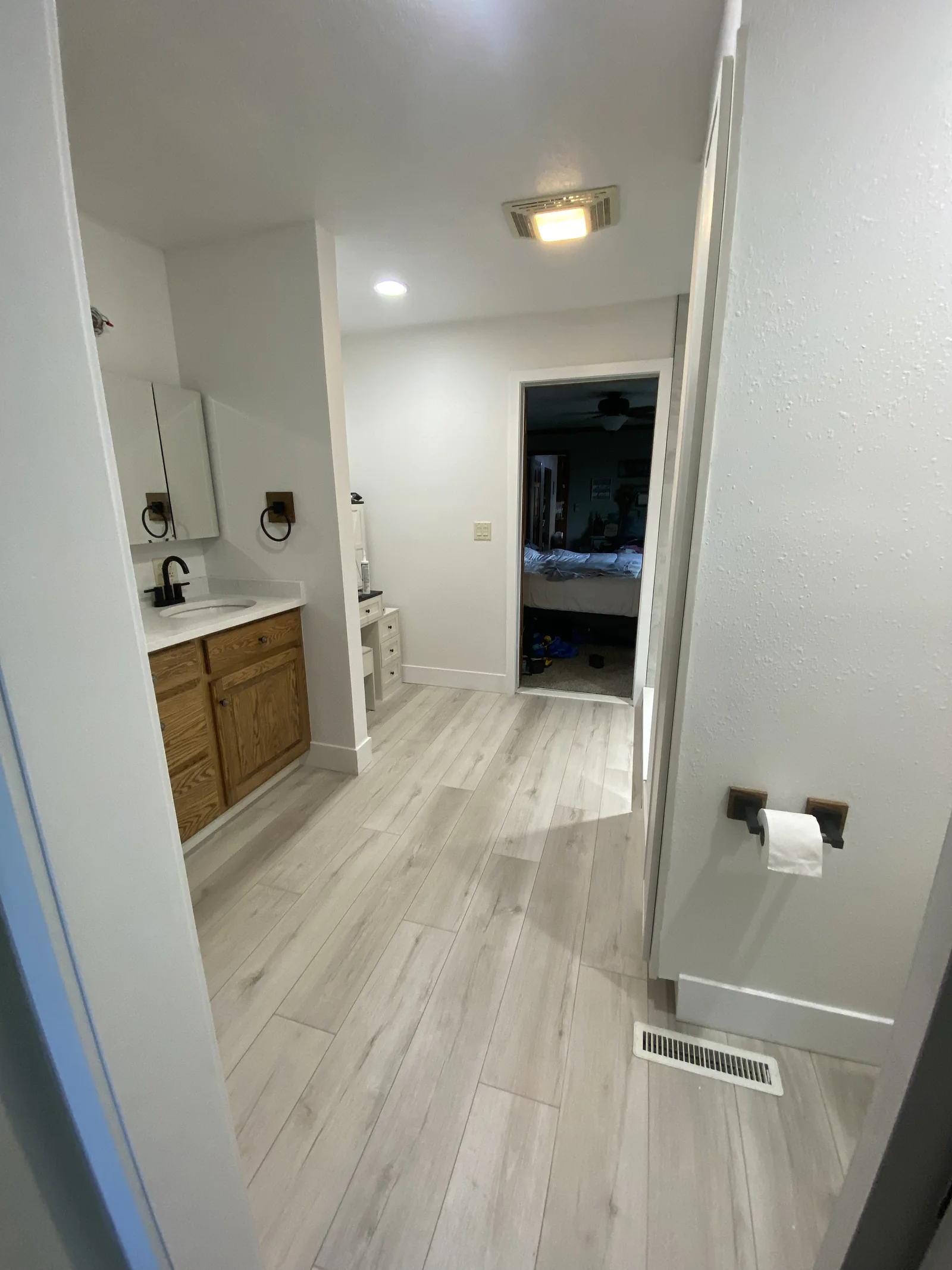 Bathroom with wood-look flooring and wood vanity