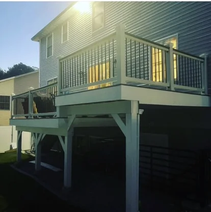 Raised deck with black railings beside house siding